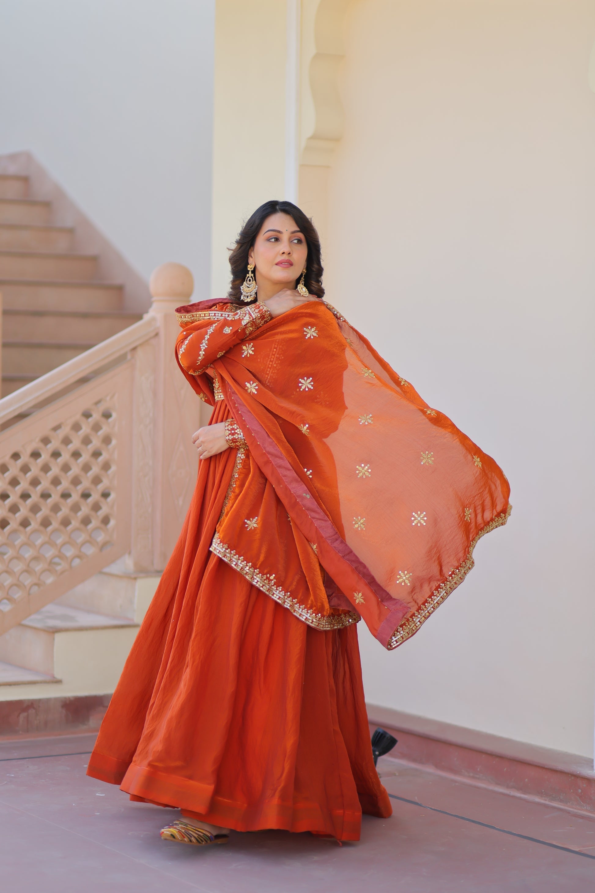 Varnita Orange Gown in Fendy Silk with zari & sequin work, full sleeves, V-neck & dupatta – regal festive wear, fully stitched.