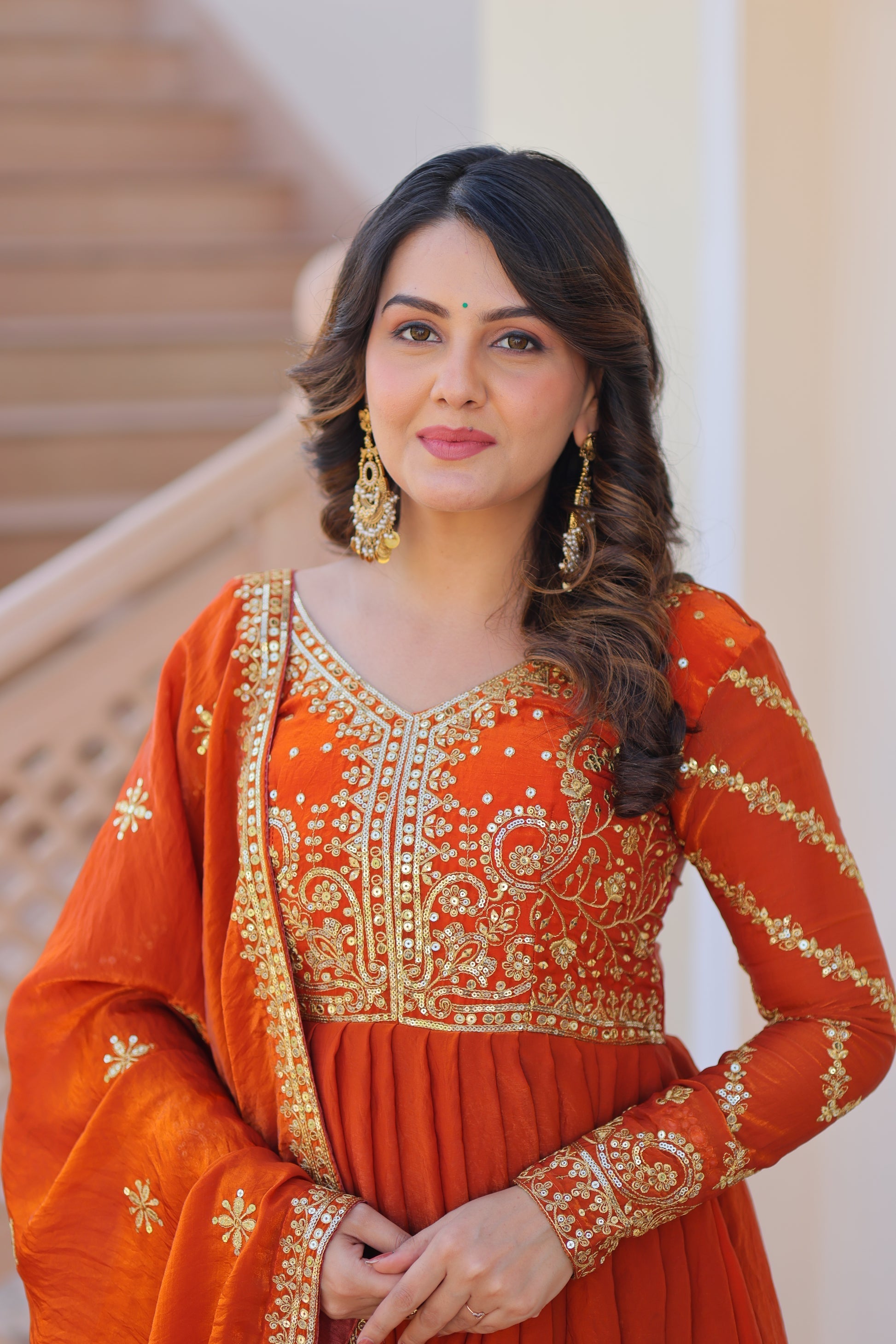 Varnita Orange Gown in Fendy Silk with zari & sequin work, full sleeves, V-neck & dupatta – regal festive wear, fully stitched.