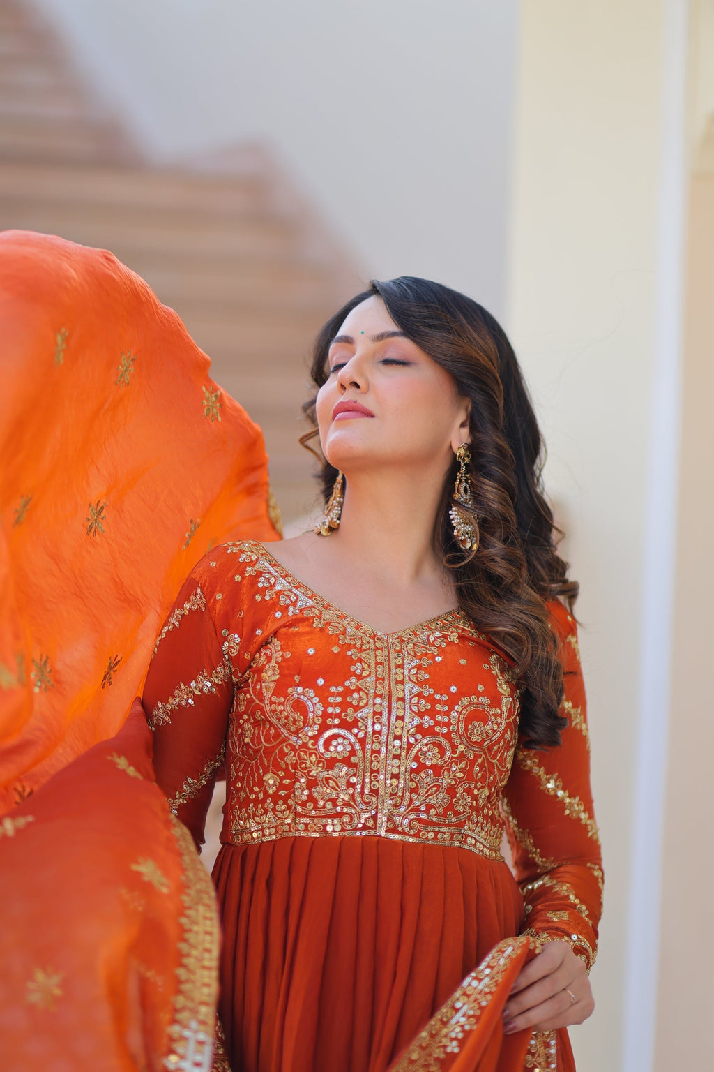 Varnita Orange Gown in Fendy Silk with zari & sequin work, full sleeves, V-neck & dupatta – regal festive wear, fully stitched.
