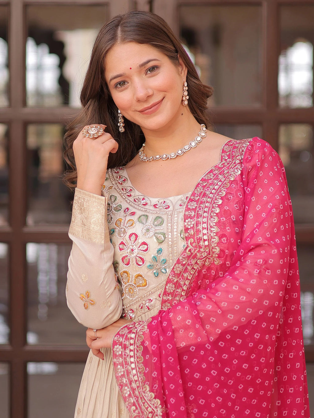 Cream silk gown with pearl beads embroidery and pink bandhani dupatta
