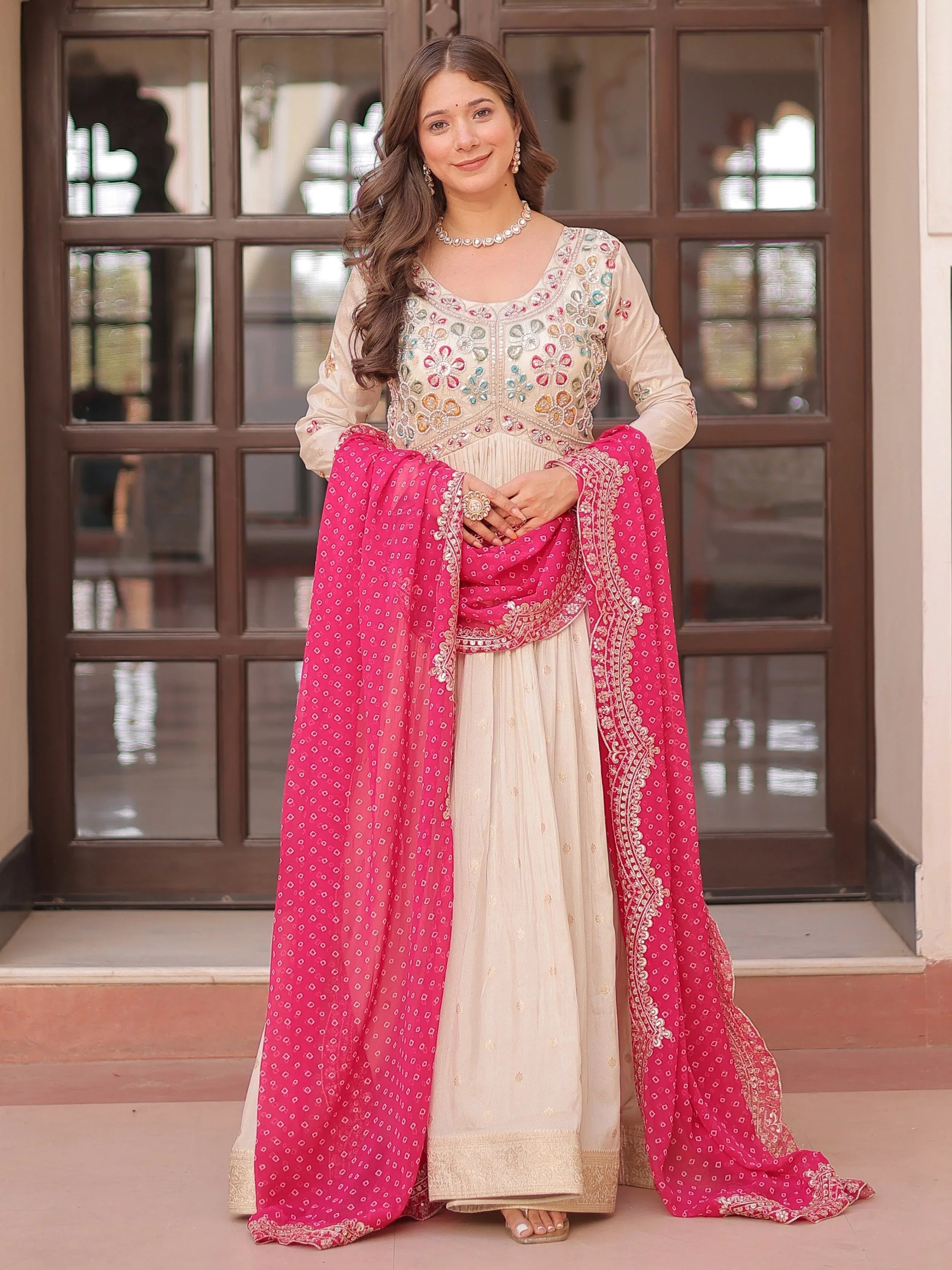 Cream silk gown with pearl beads embroidery and pink bandhani dupatta