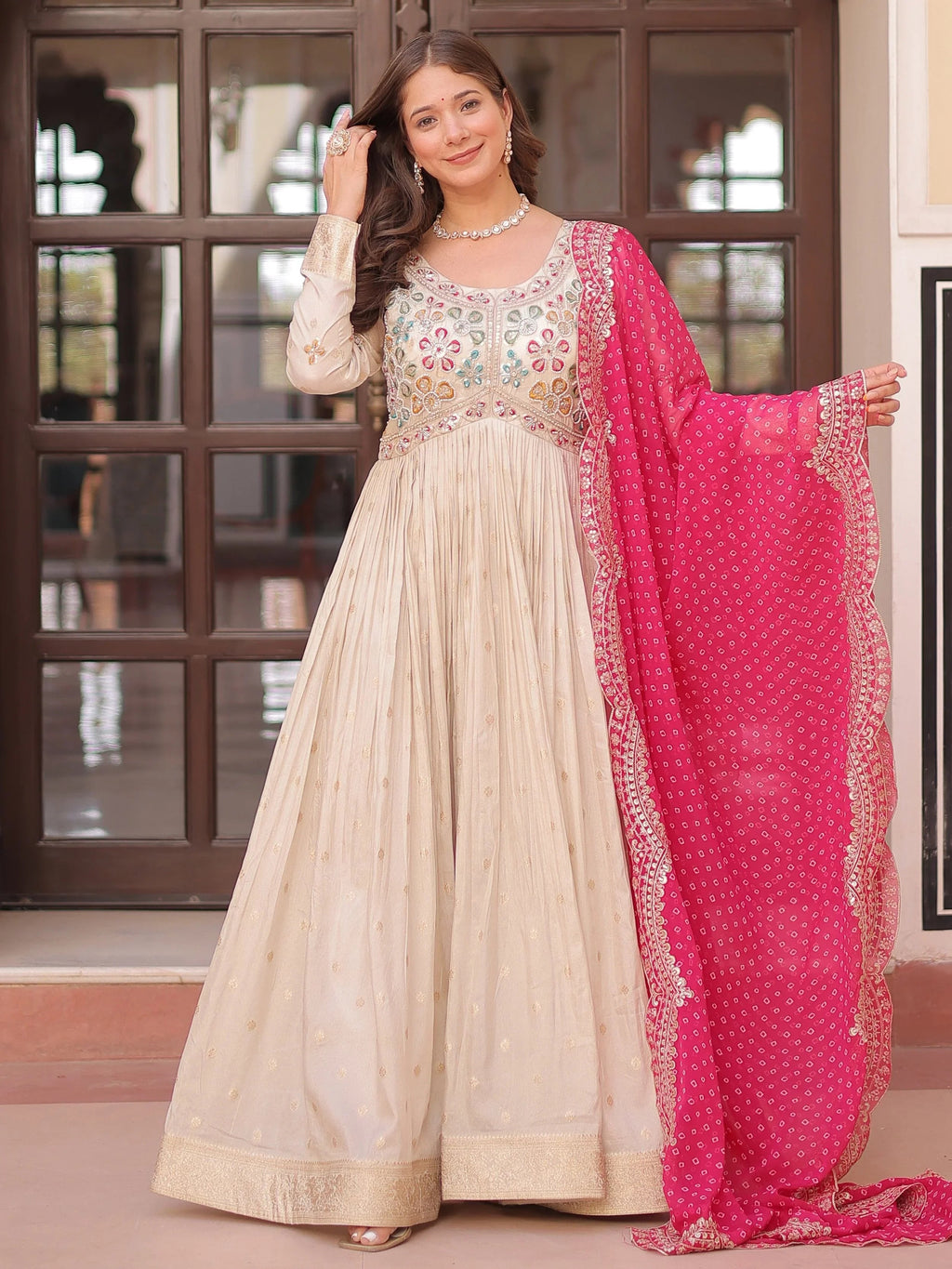 Cream silk gown with pearl beads embroidery and pink bandhani dupatta