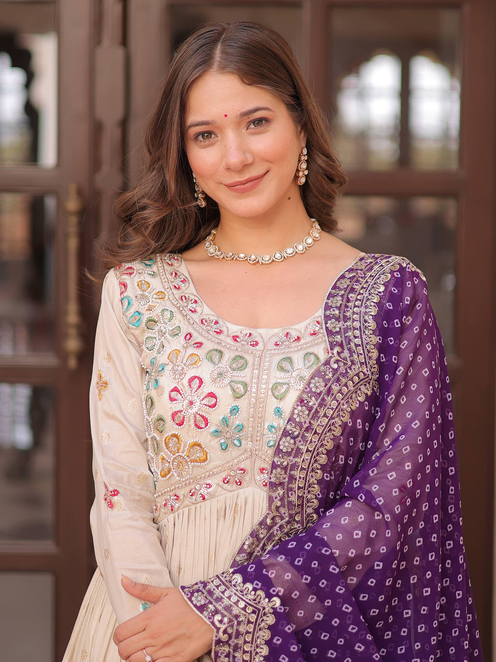 Cream silk gown with pearl beads embroidery and purple bandhani dupatta