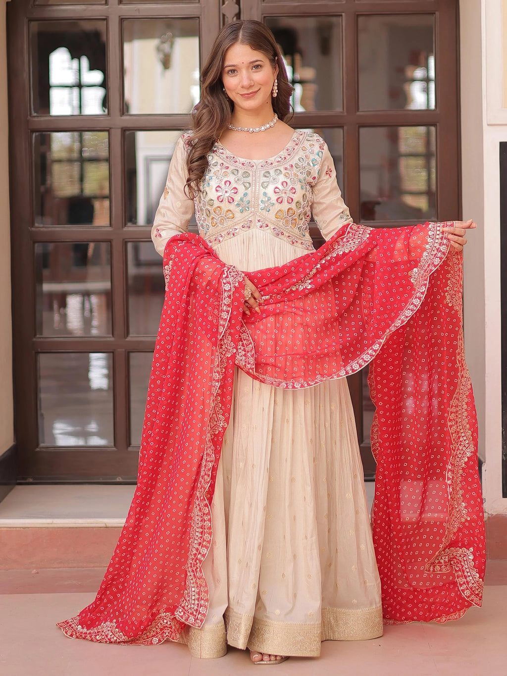 Cream silk gown with pearl beads embroidery and red bandhani dupatta