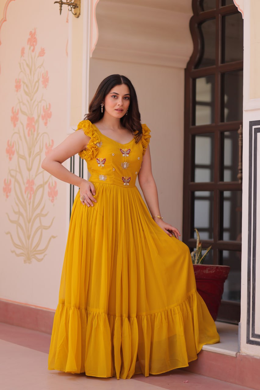 Lavi 7-meter flared designer gown in faux blooming fabric with sequin & bead embroidery, V-neck & frill shoulders – perfect for weddings & parties.