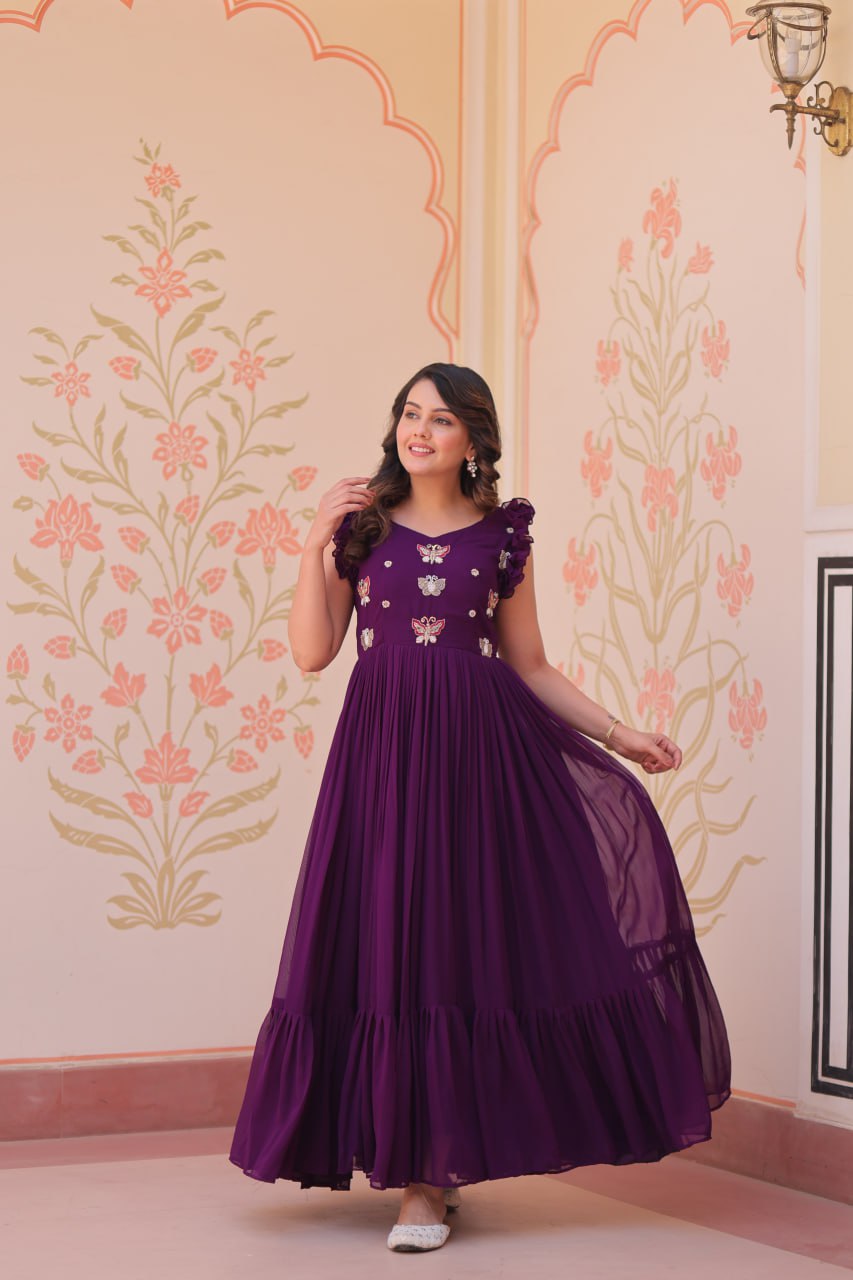 Lavi 7-meter flared designer gown in faux blooming fabric with sequin & bead embroidery, V-neck & frill shoulders – perfect for weddings & parties.