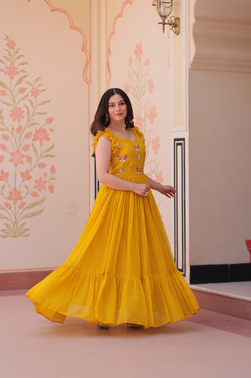 Lavi 7-meter flared designer gown in faux blooming fabric with sequin & bead embroidery, V-neck & frill shoulders – perfect for weddings & parties.