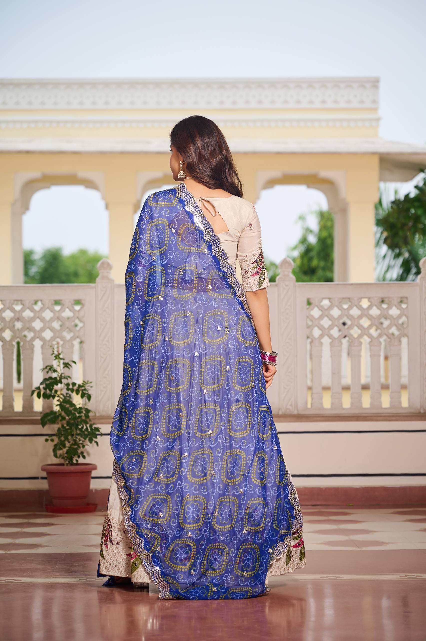 Amla off-white tissue silk lehenga choli with sequins thread work and blue Bandhej dupatta