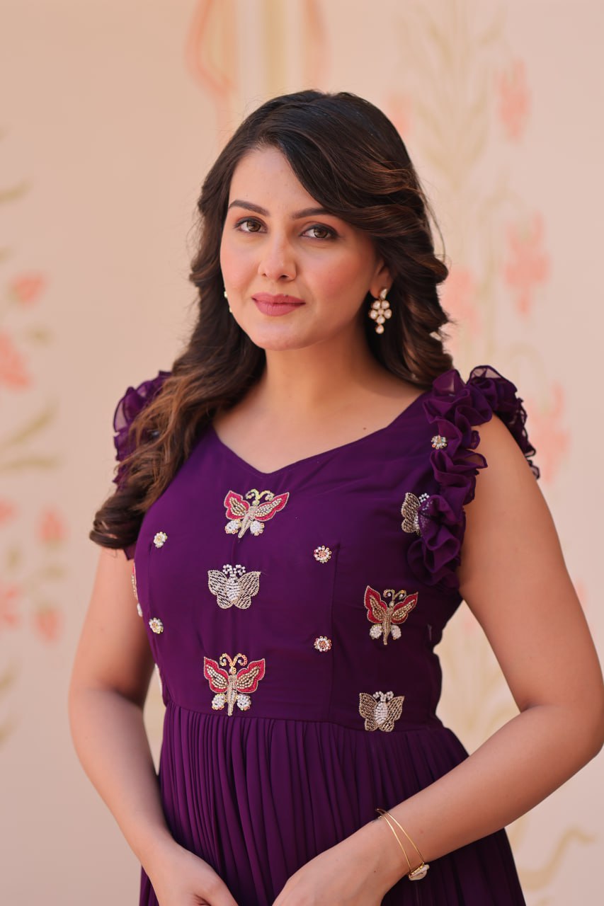 Lavi 7-meter flared designer gown in faux blooming fabric with sequin & bead embroidery, V-neck & frill shoulders – perfect for weddings & parties.