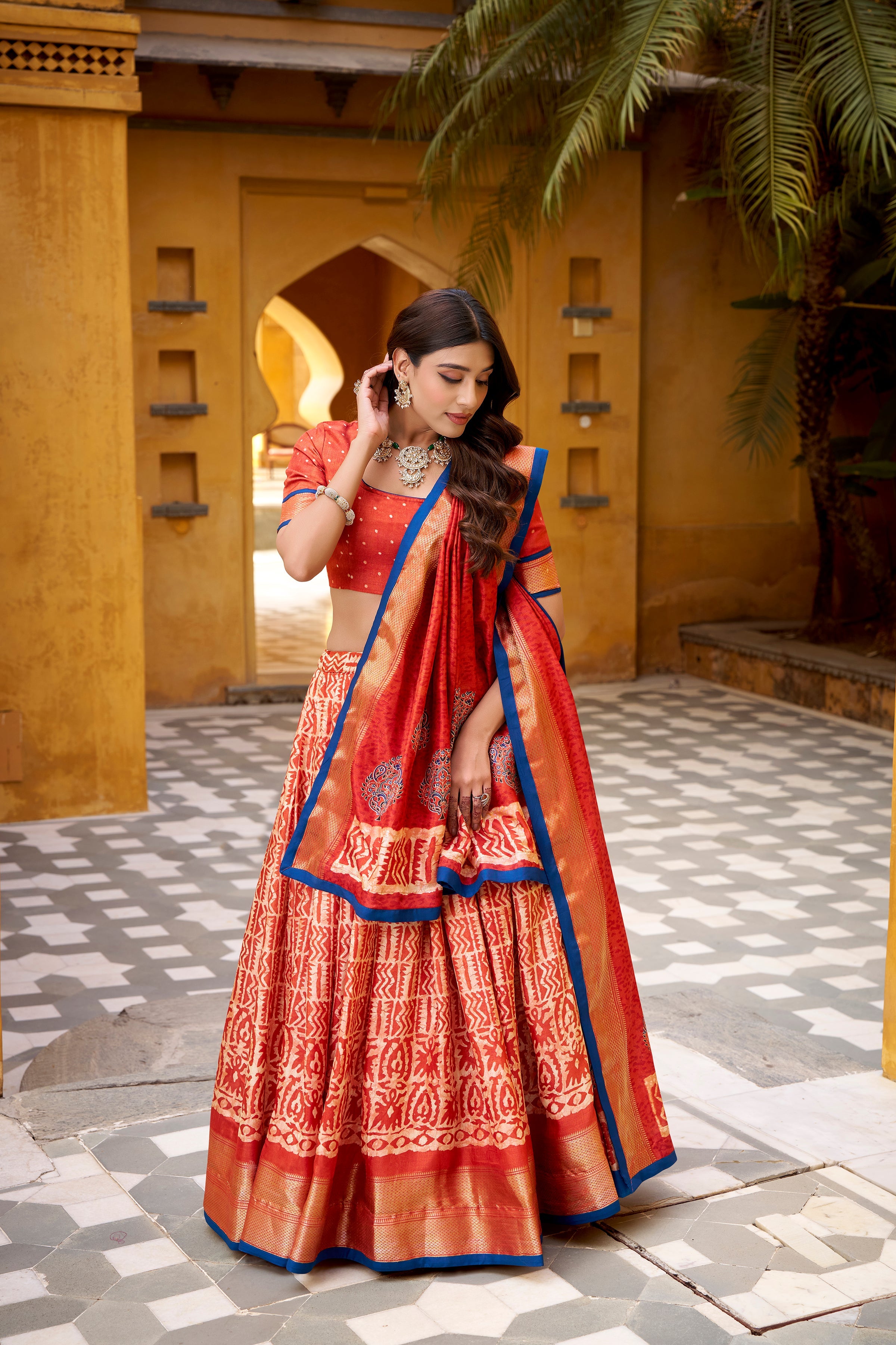 Girija rust orange Dola silk batik print lehenga choli with zari weaving work