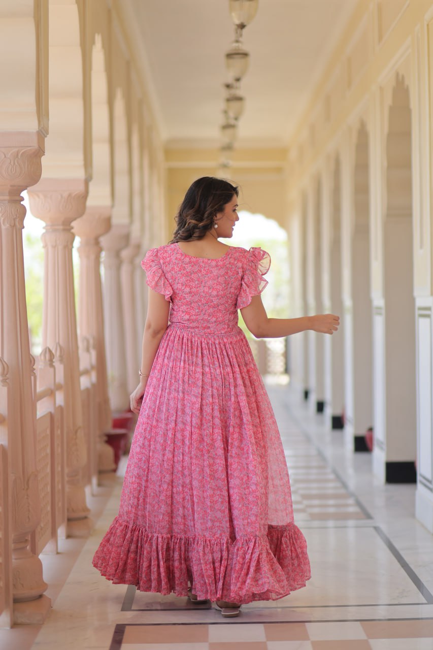 Printed pink georgette gown for women with 7-meter flair, bell sleeves & V-neck—lightweight ethnic dress for Haldi, Mehendi, Navratri & festive functions.
