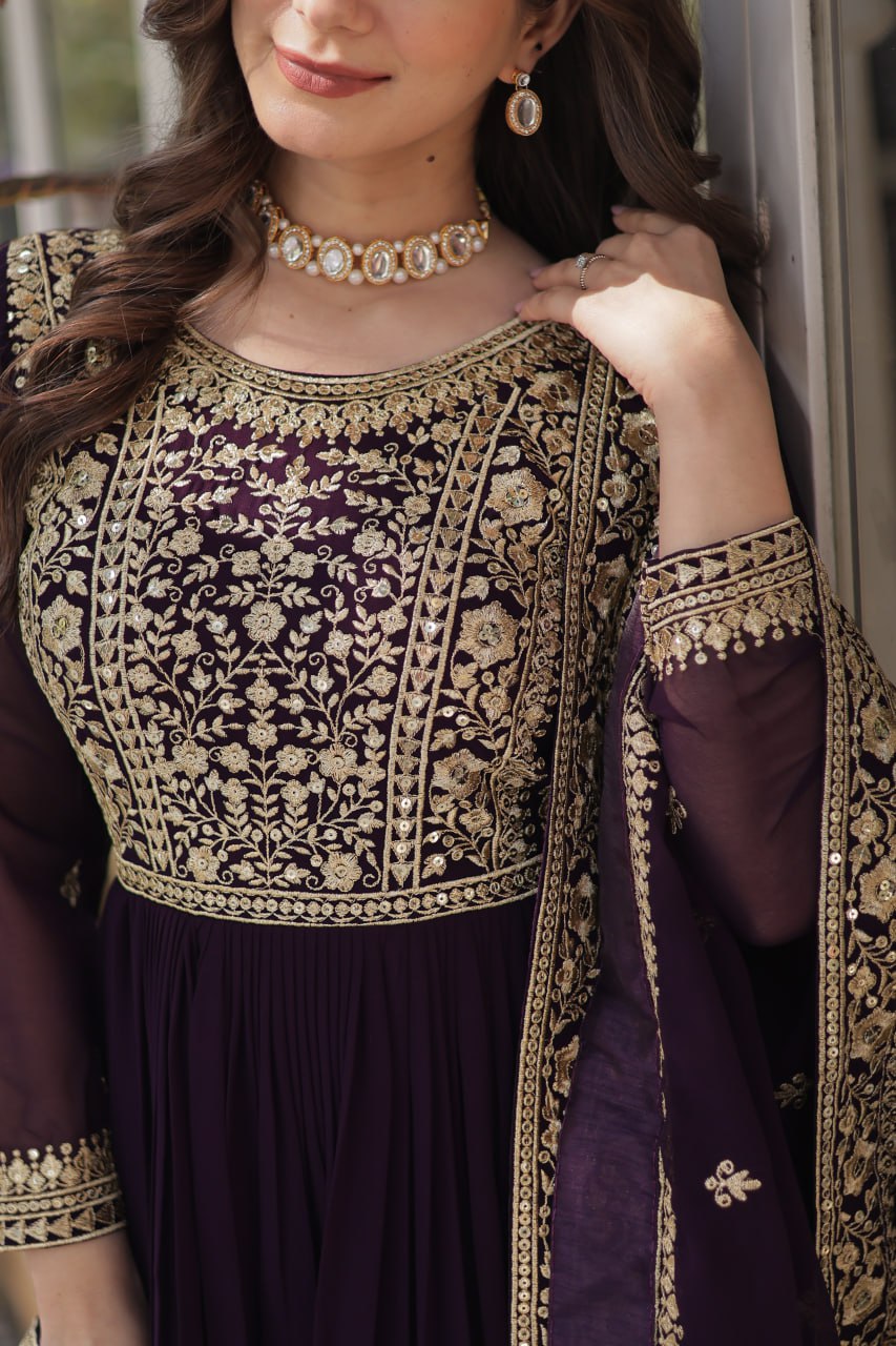 Suvarnita wine embroidered ethnic gown set with zari and sequin work, featuring full sleeves, round neck, flared 56-inch faux blooming gown and matching dupatta – ideal Indian party wear gown for weddings and festive occasions.